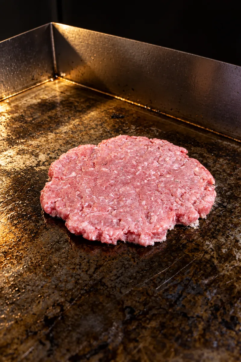 Scottona cruda appena schiacciata sulla piastra