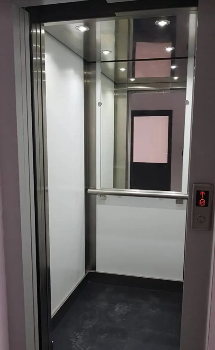 Cabina con pareti chiare e corrimano
