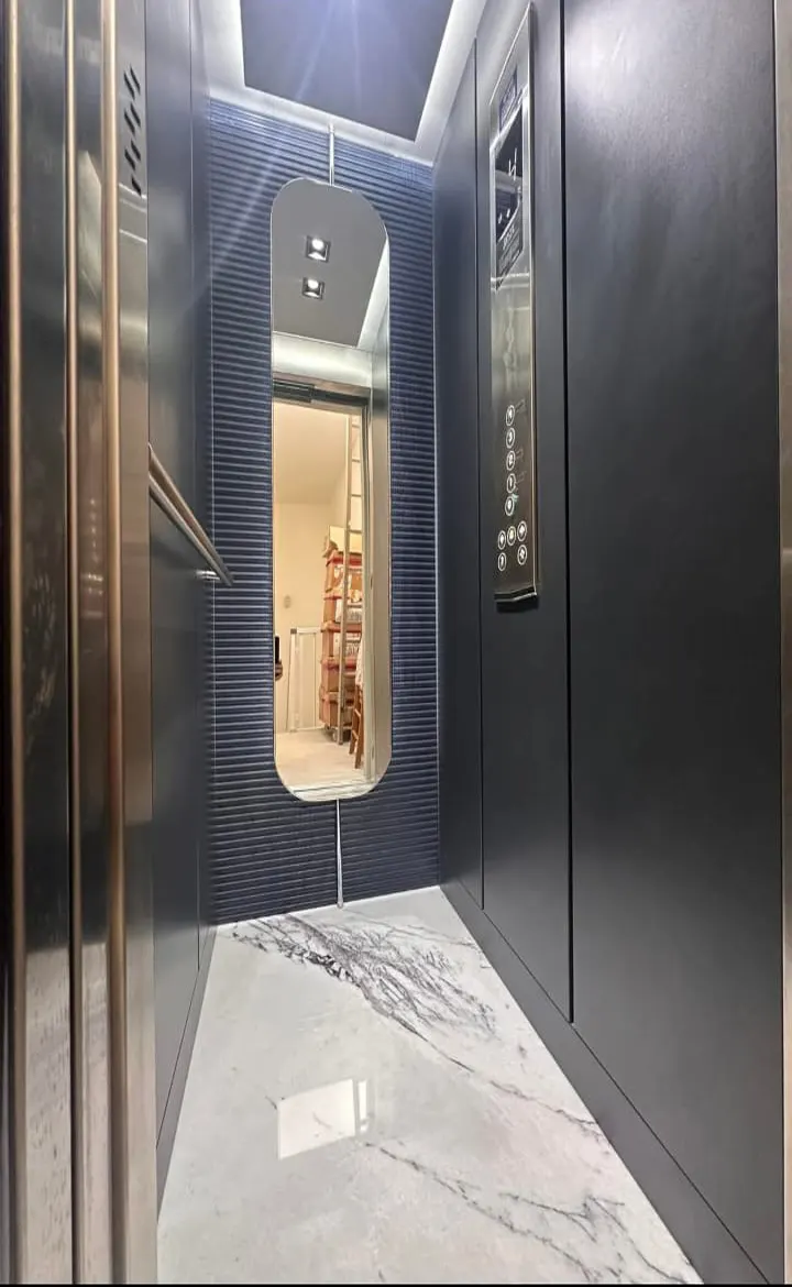Cabina con parete blu, specchio e pavimento in marmo